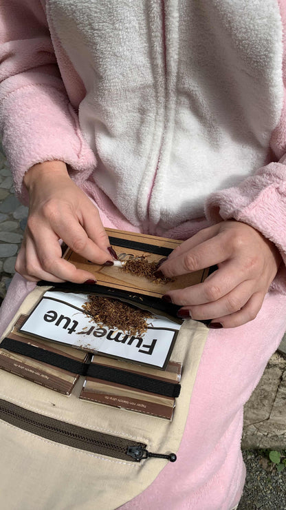 Rouler une cigarette sur la plaque en bois de la blague à tabac.